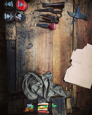 An assortment of sewing supplies displayed on a rustic wooden table.