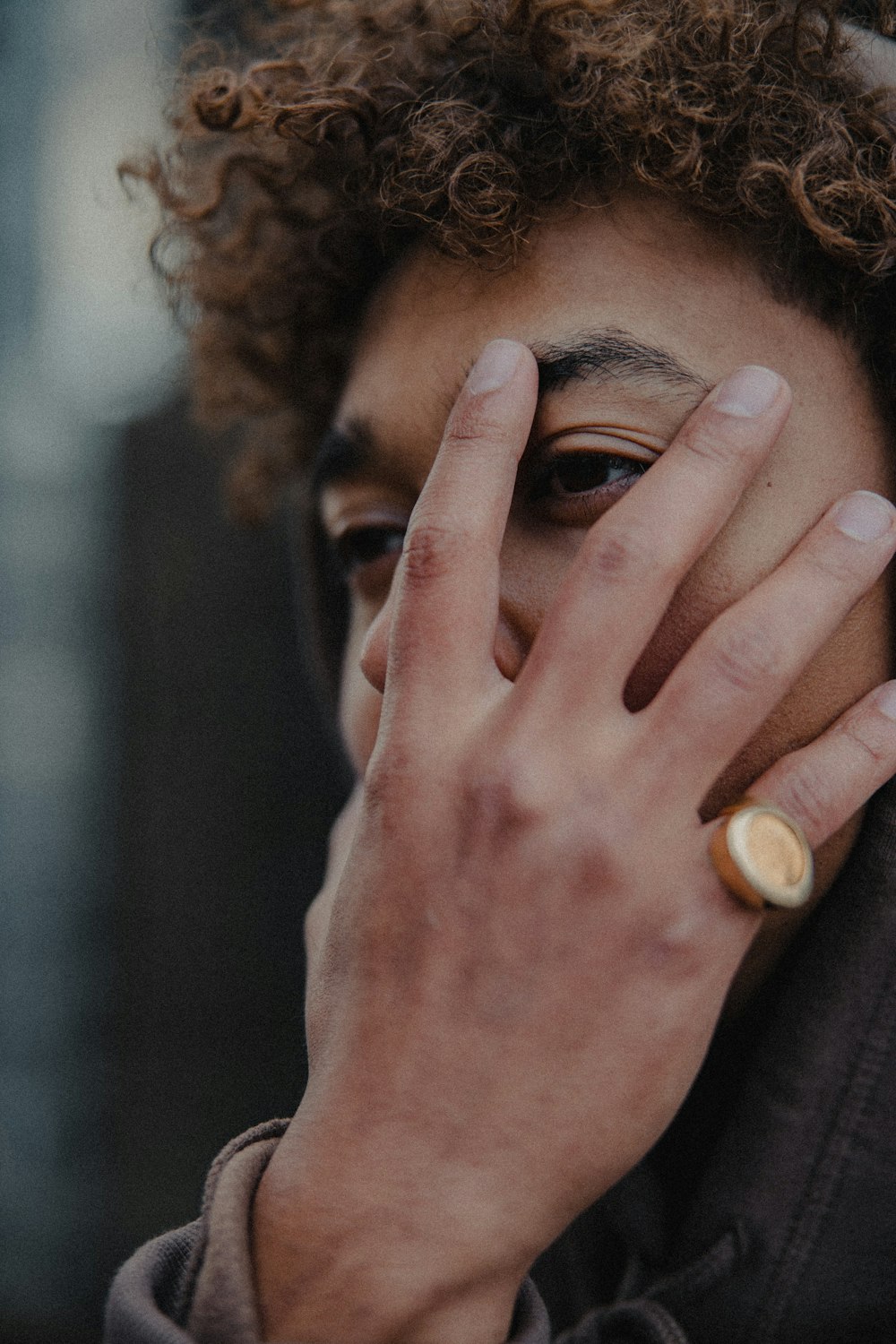 man in black shirt covering his face