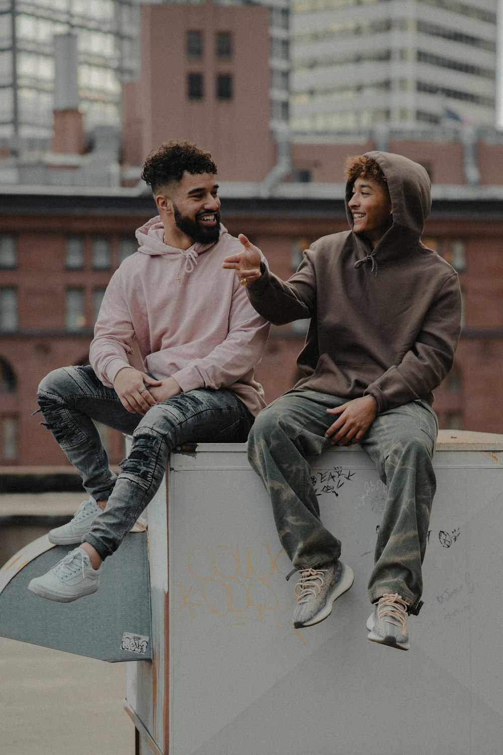 man in brown hoodie sitting beside woman in gray sweater