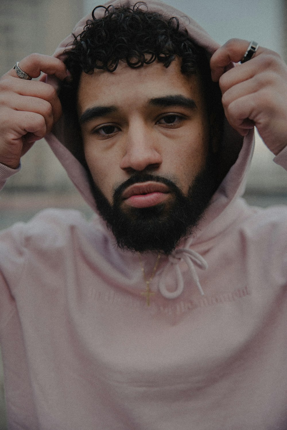 man in white hoodie holding his head