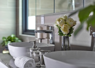 white roses on white ceramic sink