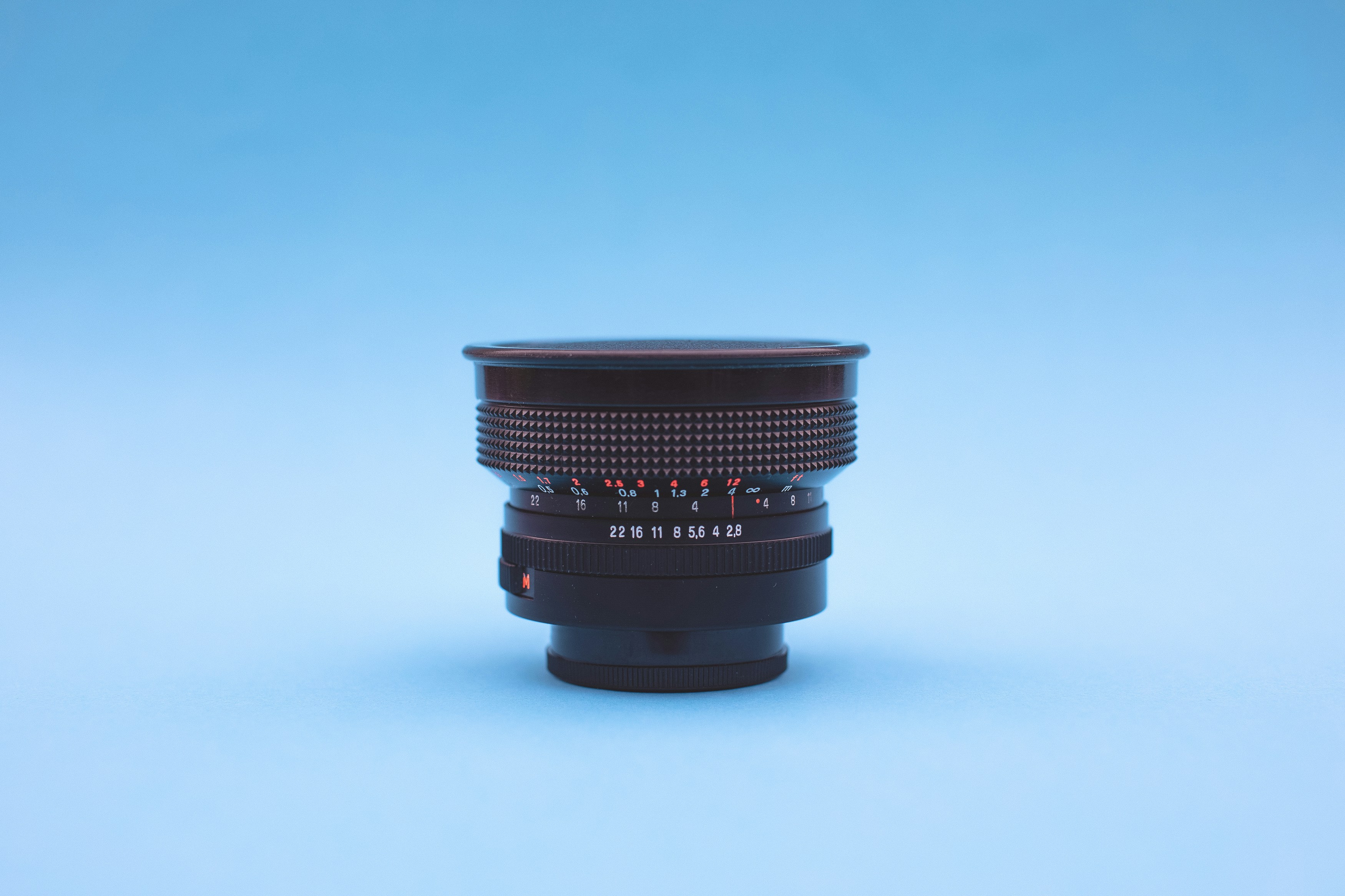 black and gray portable speaker, Vintage analog wide angle lens – Carl Zeiss Jena Flektogon red MC 2.8 20mm (Year: 1976)