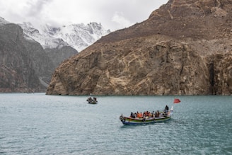 people riding on boat on sea near mountain during daytime