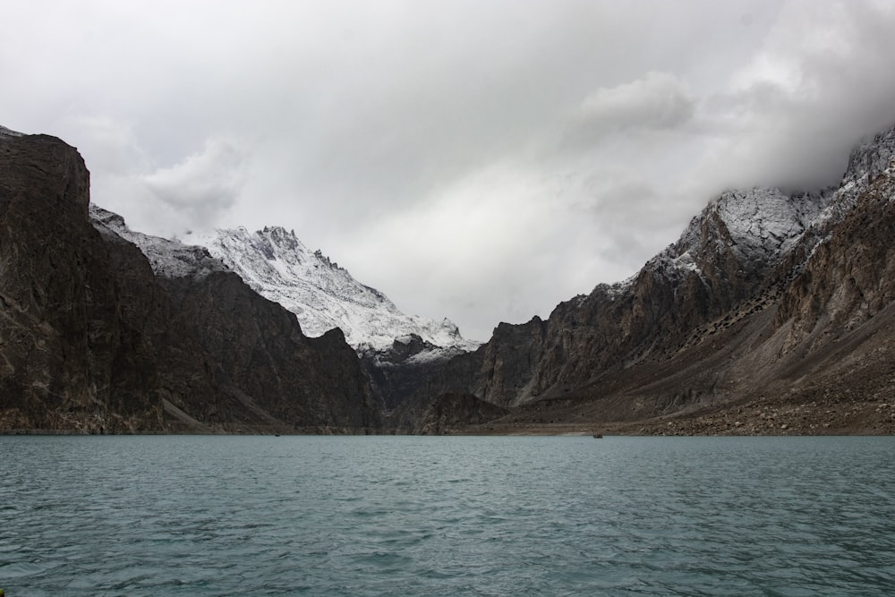 snow covered mountain near body of water during daytime