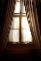Elegant wave curtains softly draping over a large window.
