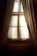 A close-up of cream-colored curtains gracefully framing a sunny window.