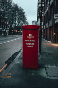 Parcel being handed over to a UK postal worker outside a modern home.