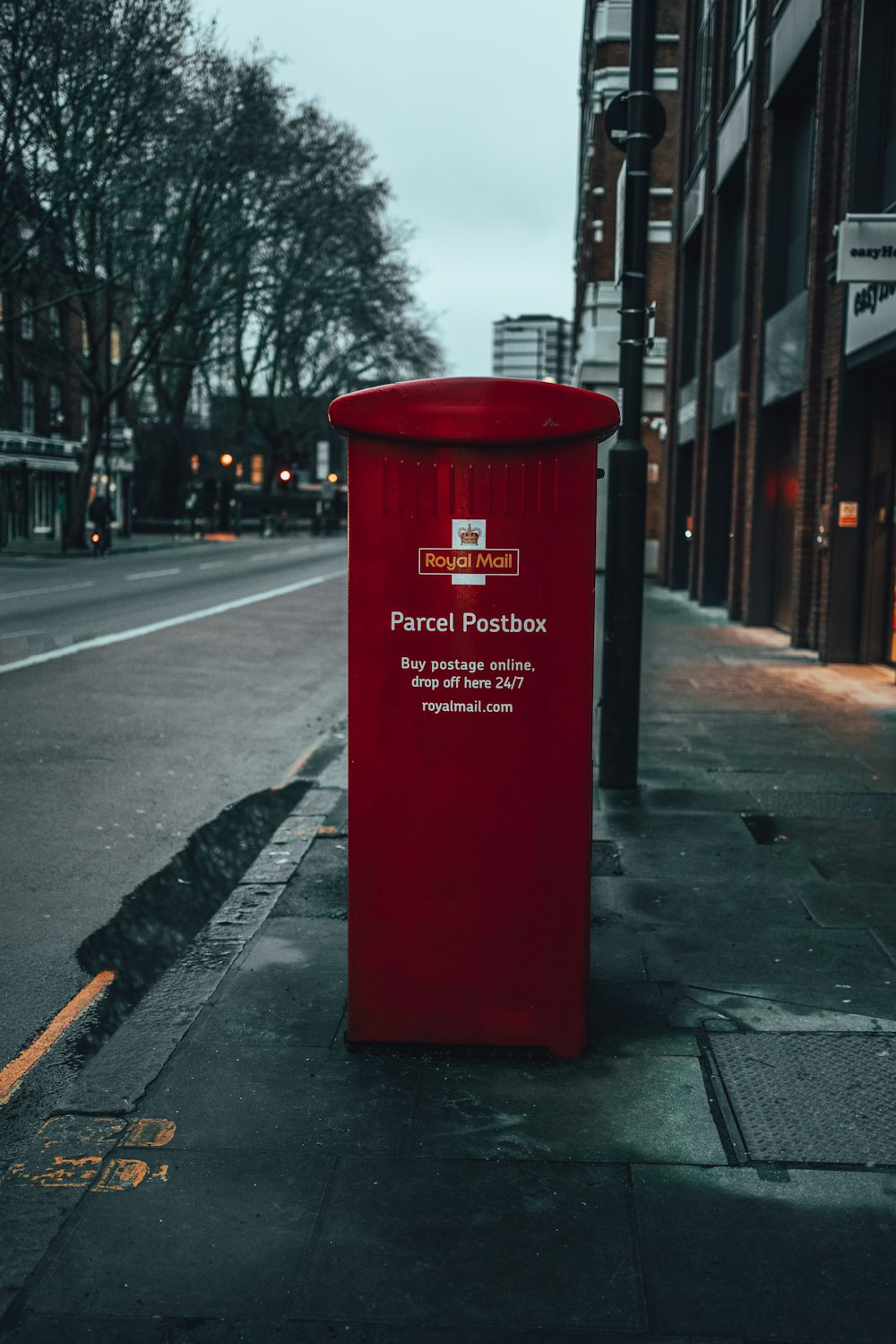 red mail box on sidewalk during night time