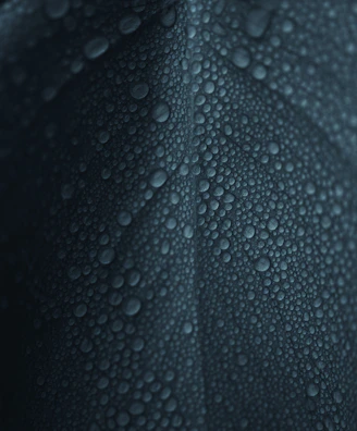 Detailed view of water droplets sliding off a freshly cleaned photovoltaic panel.