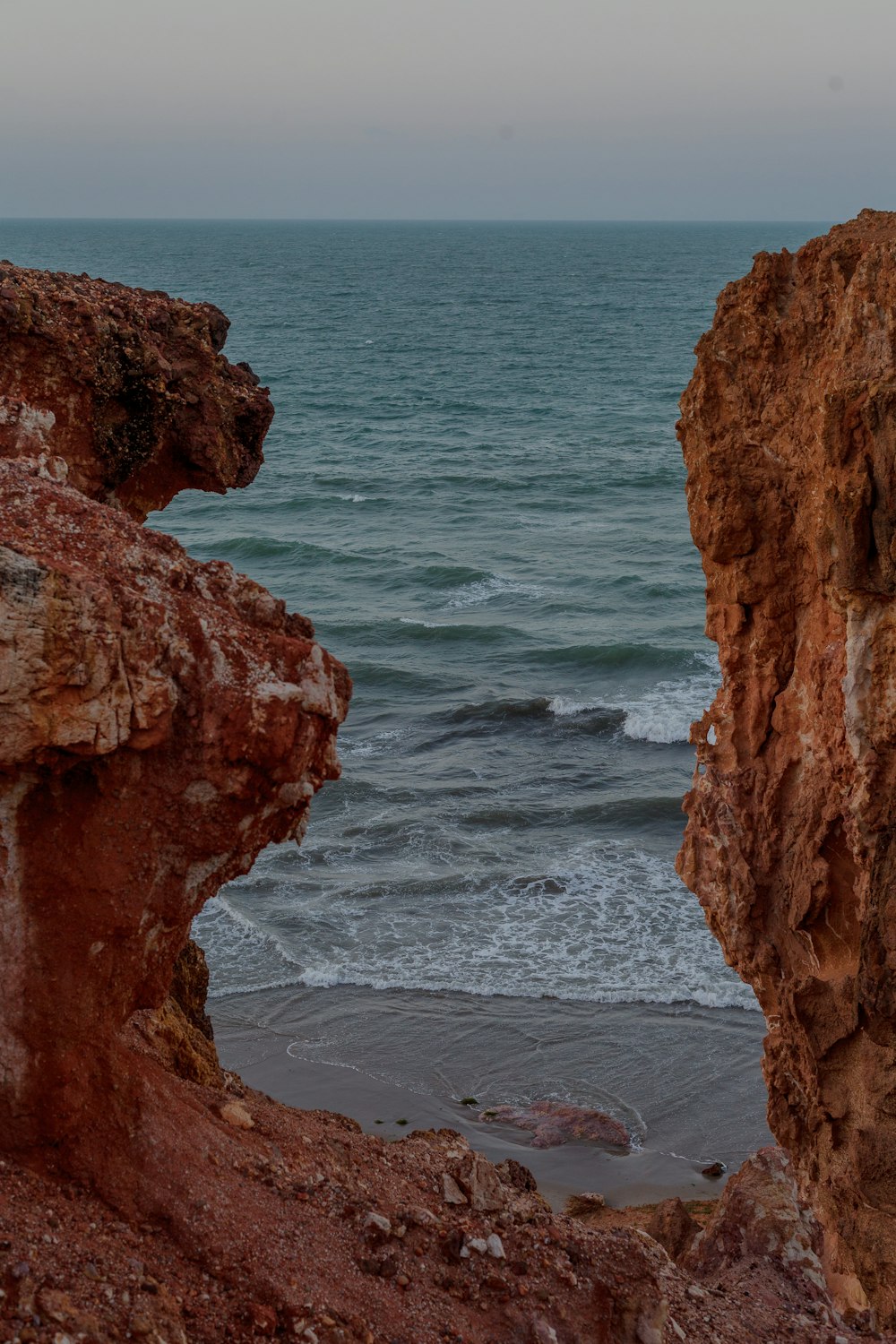 brown rock formation near body of water during daytime