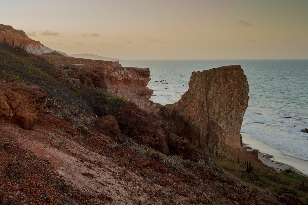 brown rock formation near body of water during daytime