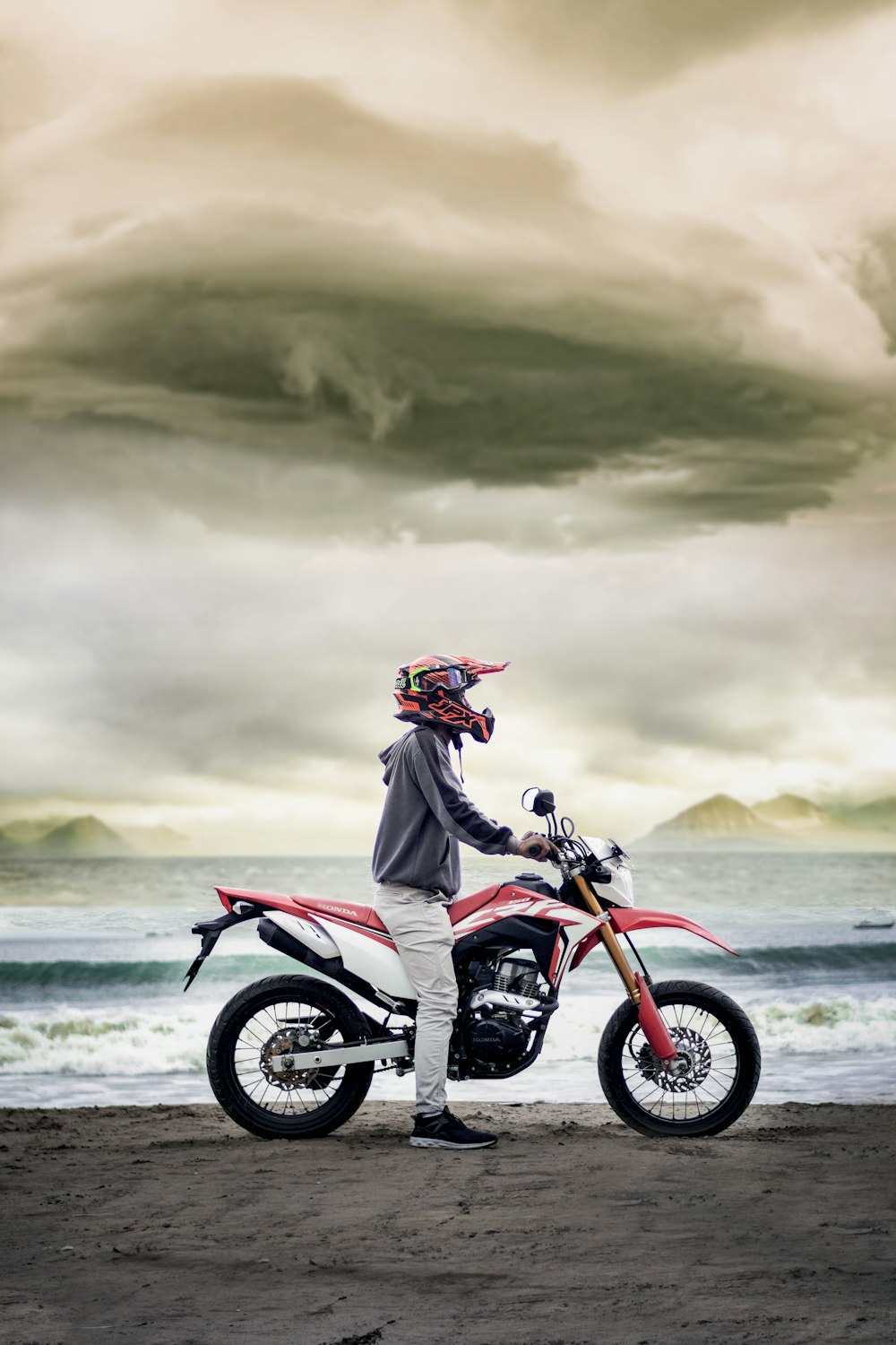 hombre con chaqueta negra montando motocicleta en la playa durante el día