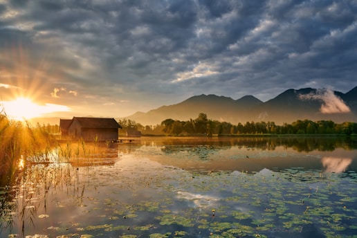 A serene sunrise over a peaceful lakeside cabin symbolizing early retirement freedom.