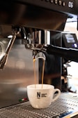 A close-up of the robotic arm pouring coffee into a cup.