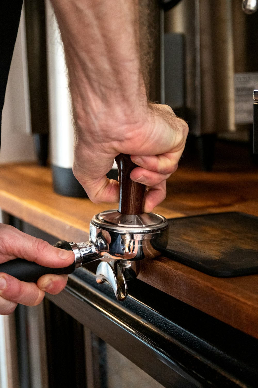 person holding silver and black coffee maker