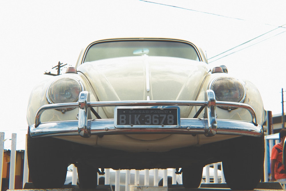 white classic car in a parking lot during daytime