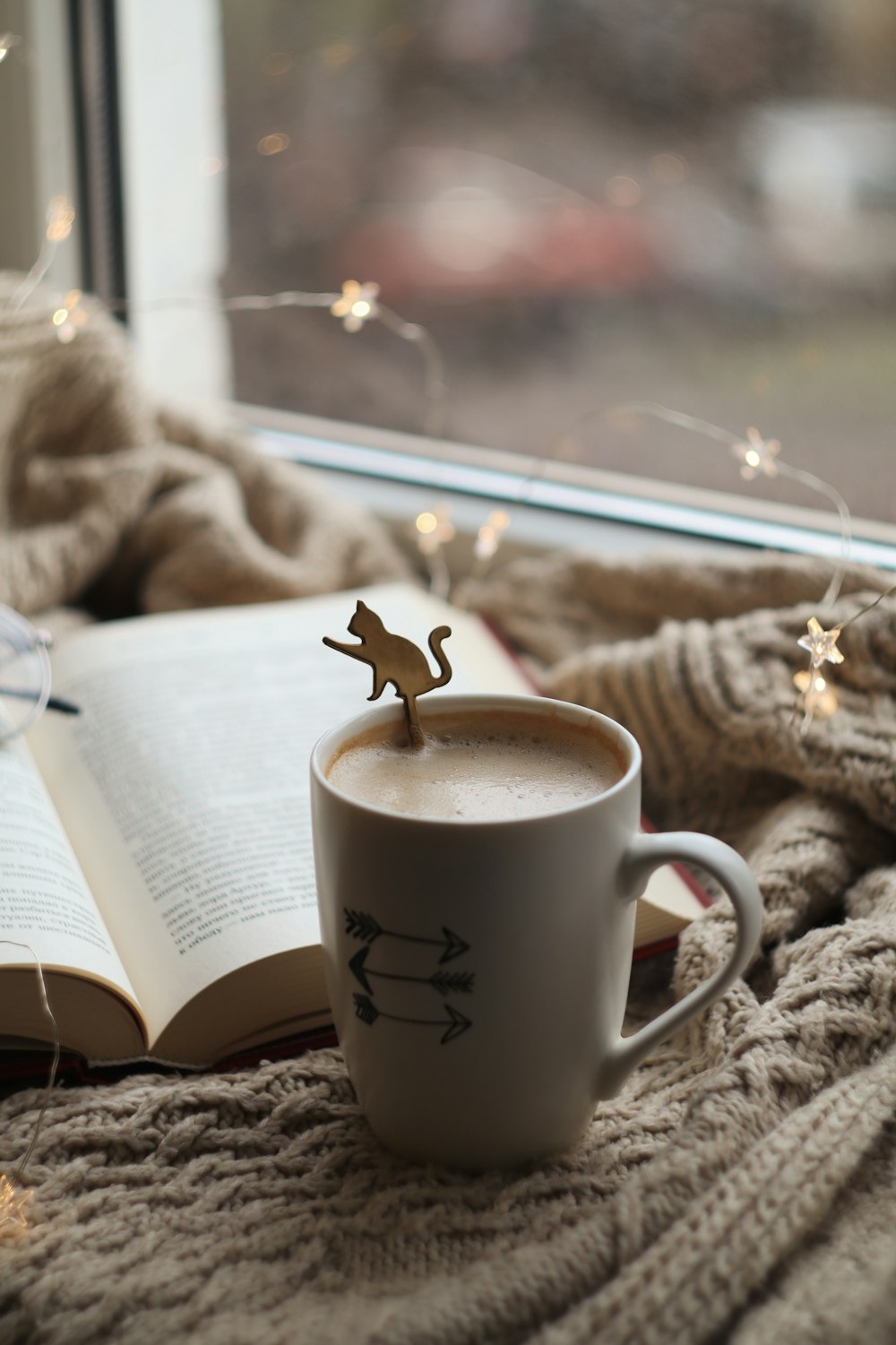 white ceramic mug with coffee on book page