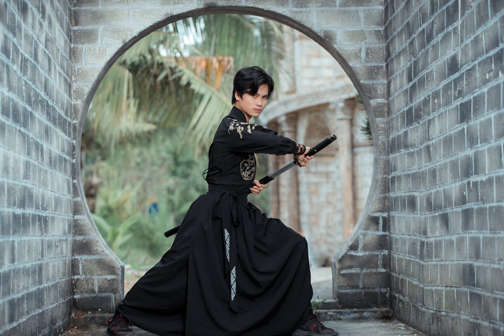 Una mujer con un vestido negro sosteniendo una espada