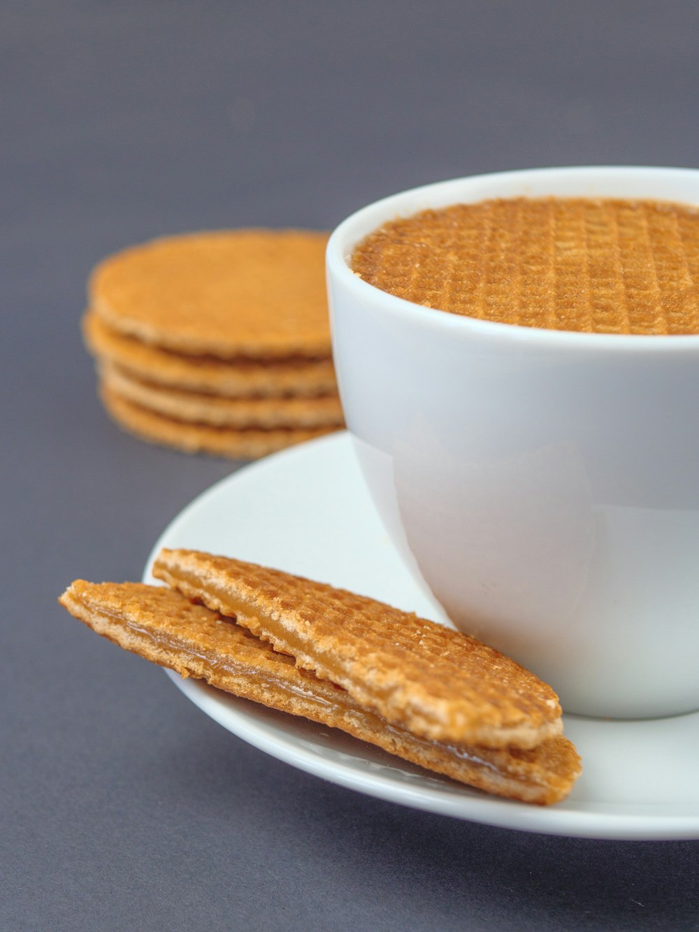 white ceramic mug with brown biscuits on white ceramic plate