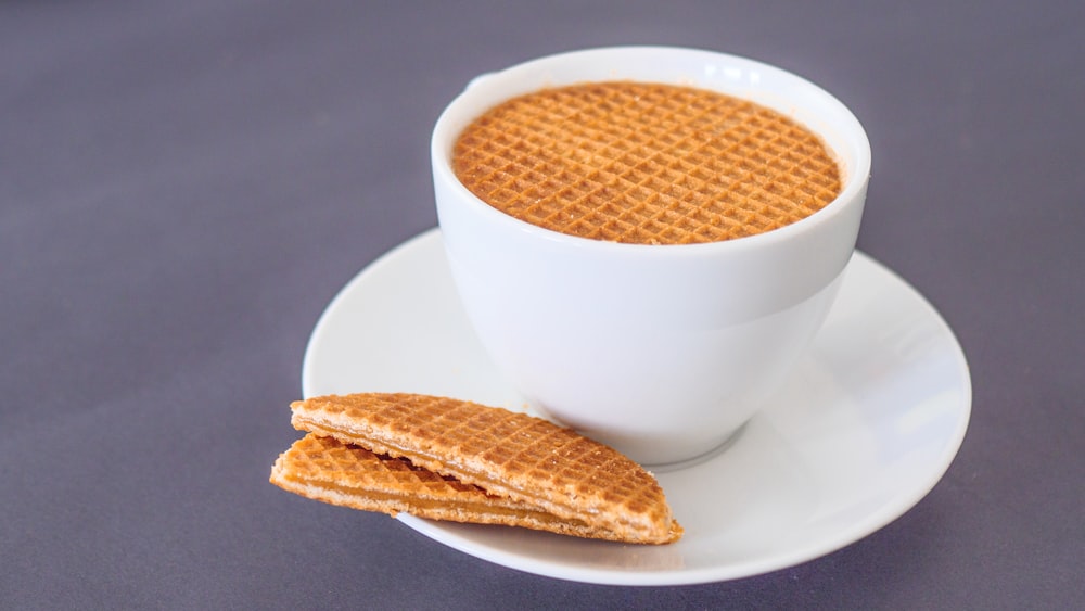 white ceramic teacup with brown liquid