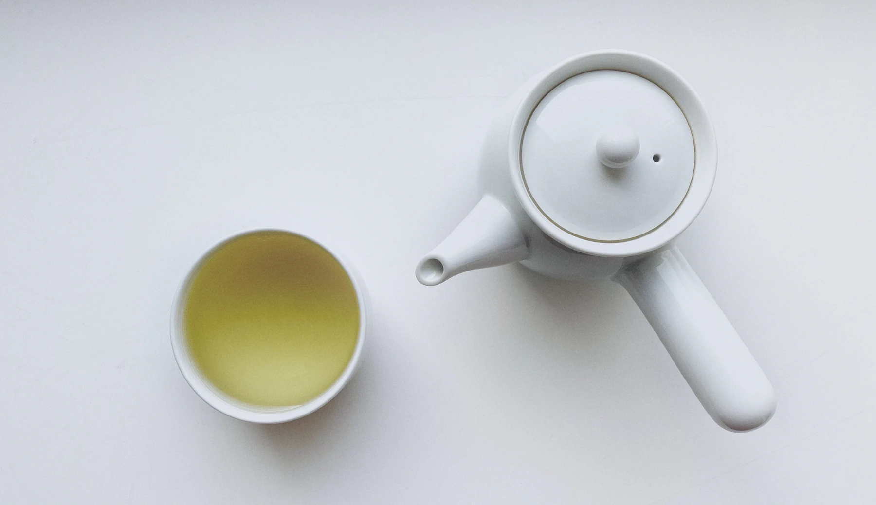 A simple white teapot and cup, a quiet still life