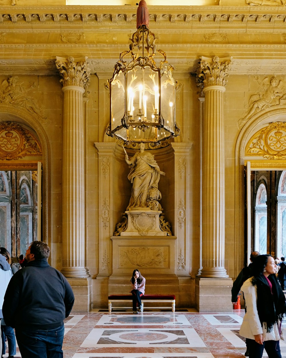 personnes assises sur un banc à l’intérieur d’un bâtiment