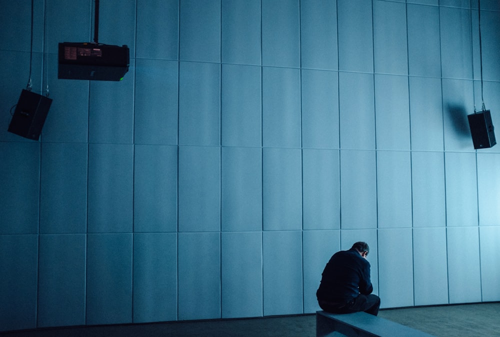 person in black hoodie sitting on floor