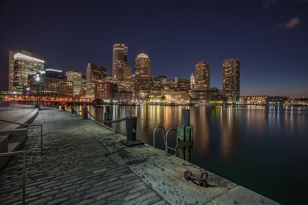 city skyline across body of water during night time