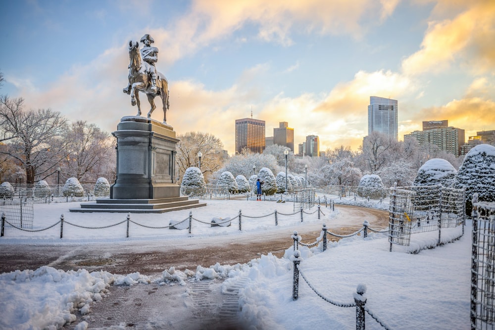 homem que monta estátua a cavalo no chão coberto de neve durante o dia