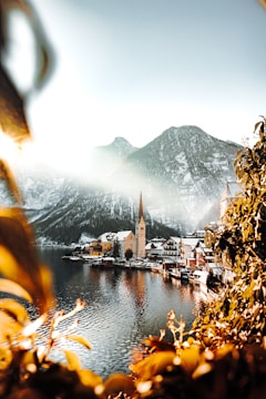 brown and white houses near body of water and mountain during daytime