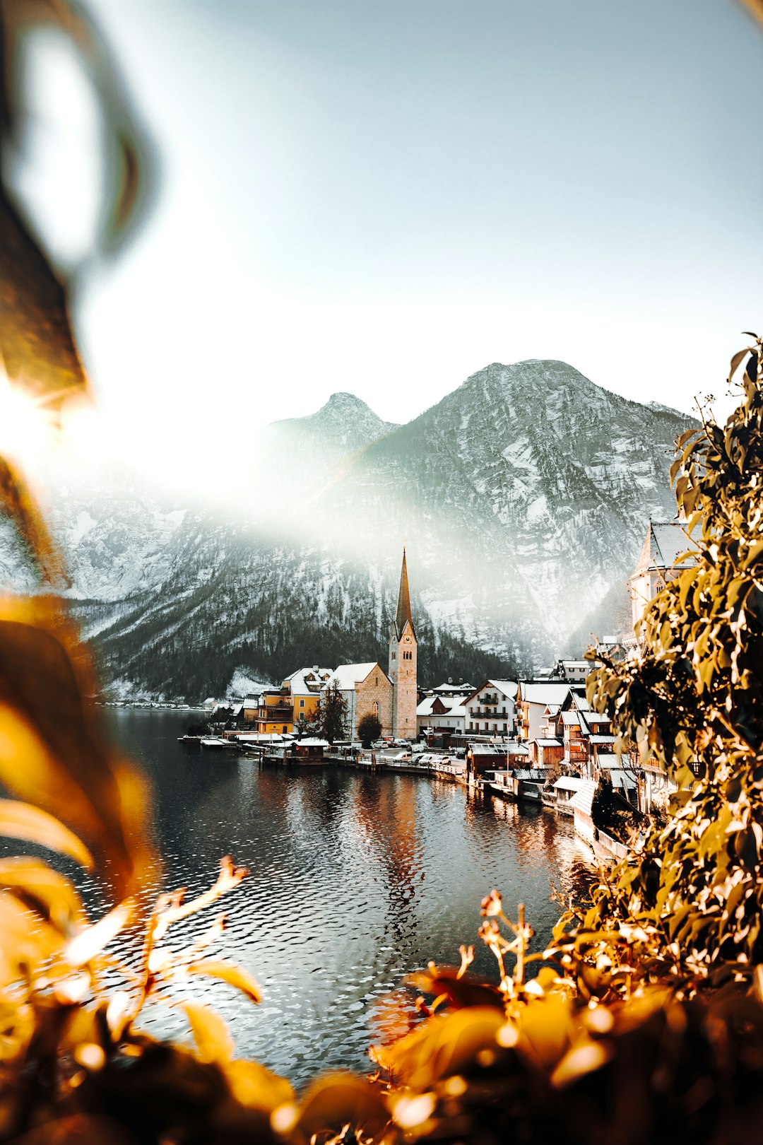 brown and white houses near body of water and mountain during daytime