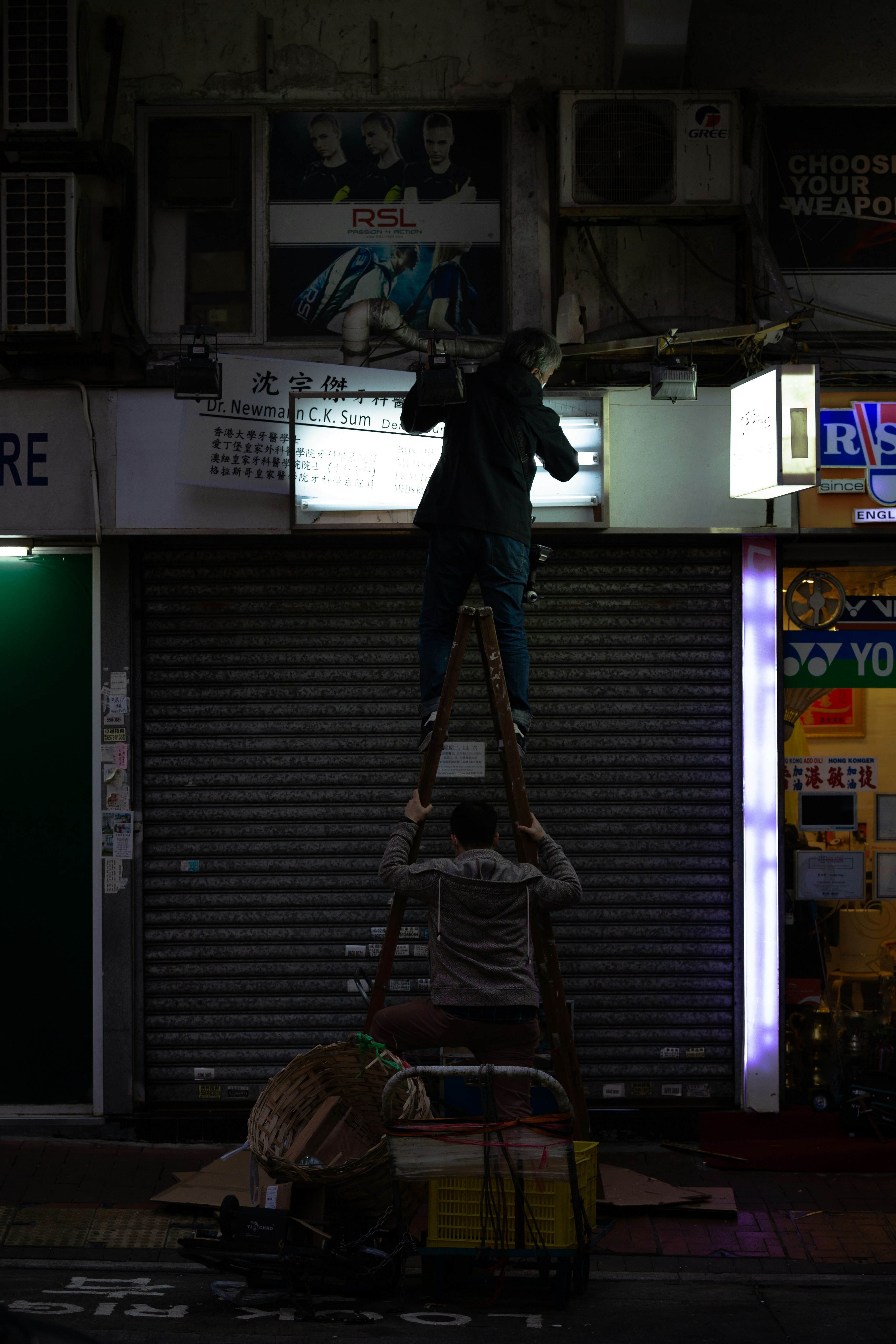 man in black jacket and blue denim jeans standing on black stairs