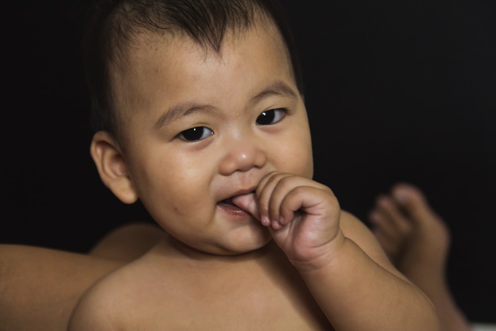 topless baby with black background