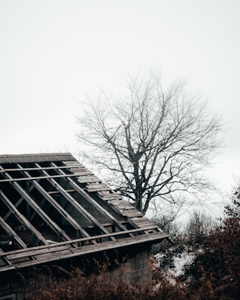 Close-up of a roof with missing shingles after a severe storm.