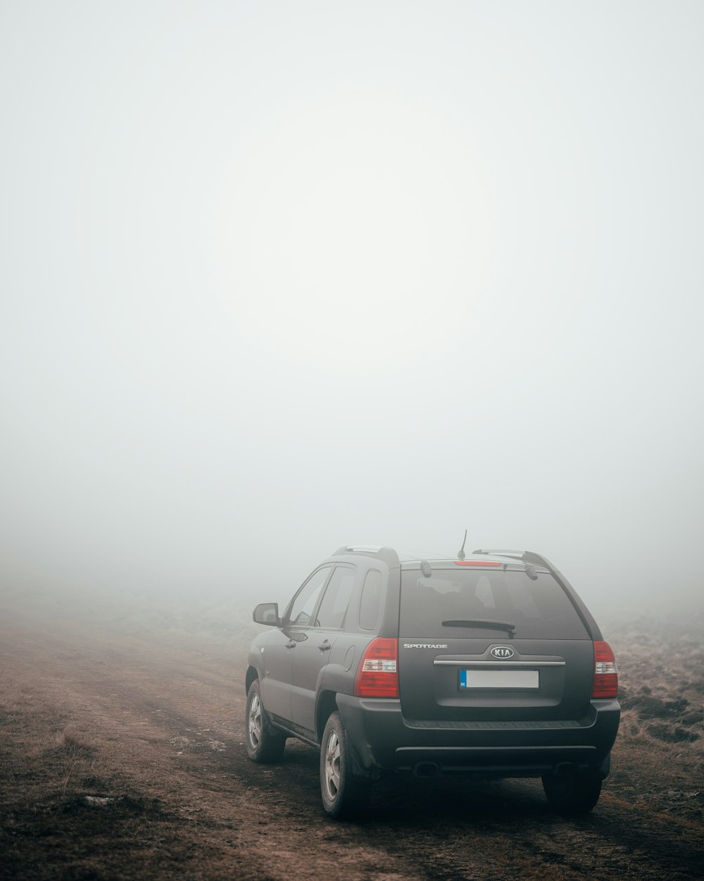 茶色の未舗装の道路に黒いSUV