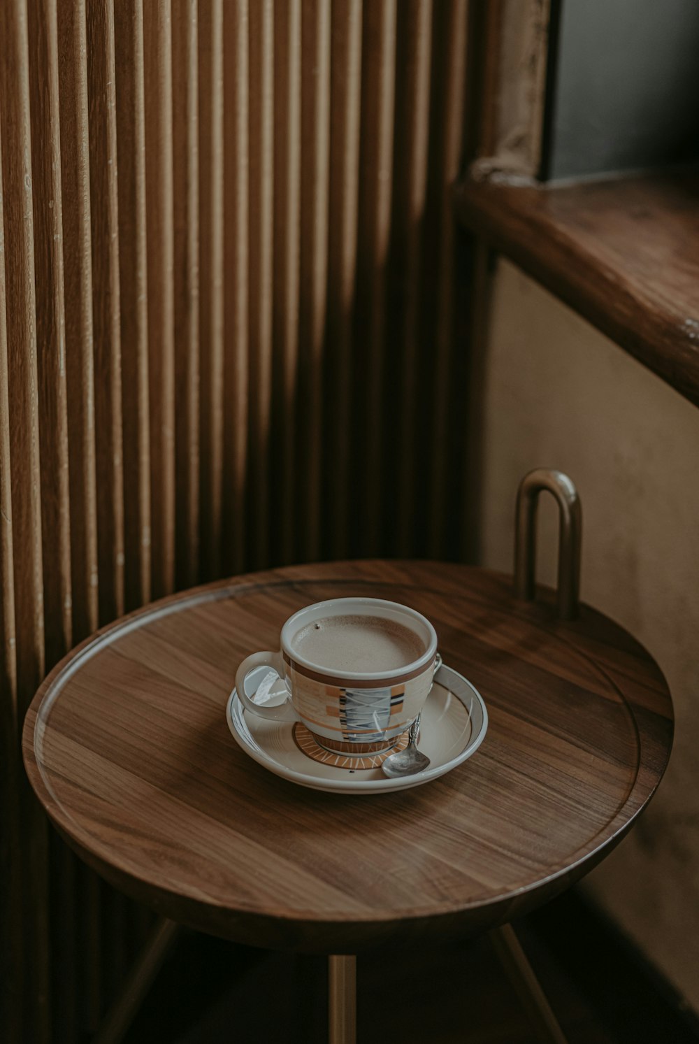 white ceramic teacup on saucer on brown wooden table