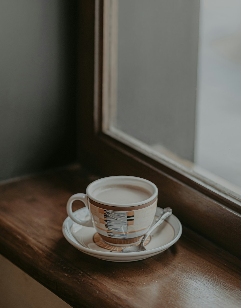 white ceramic mug on brown wooden table