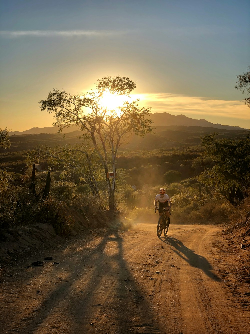 man in black jacket riding bicycle on dirt road during daytime