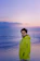 A stylish man wearing a sleek District Beach jacket standing by the waterfront at sunset.