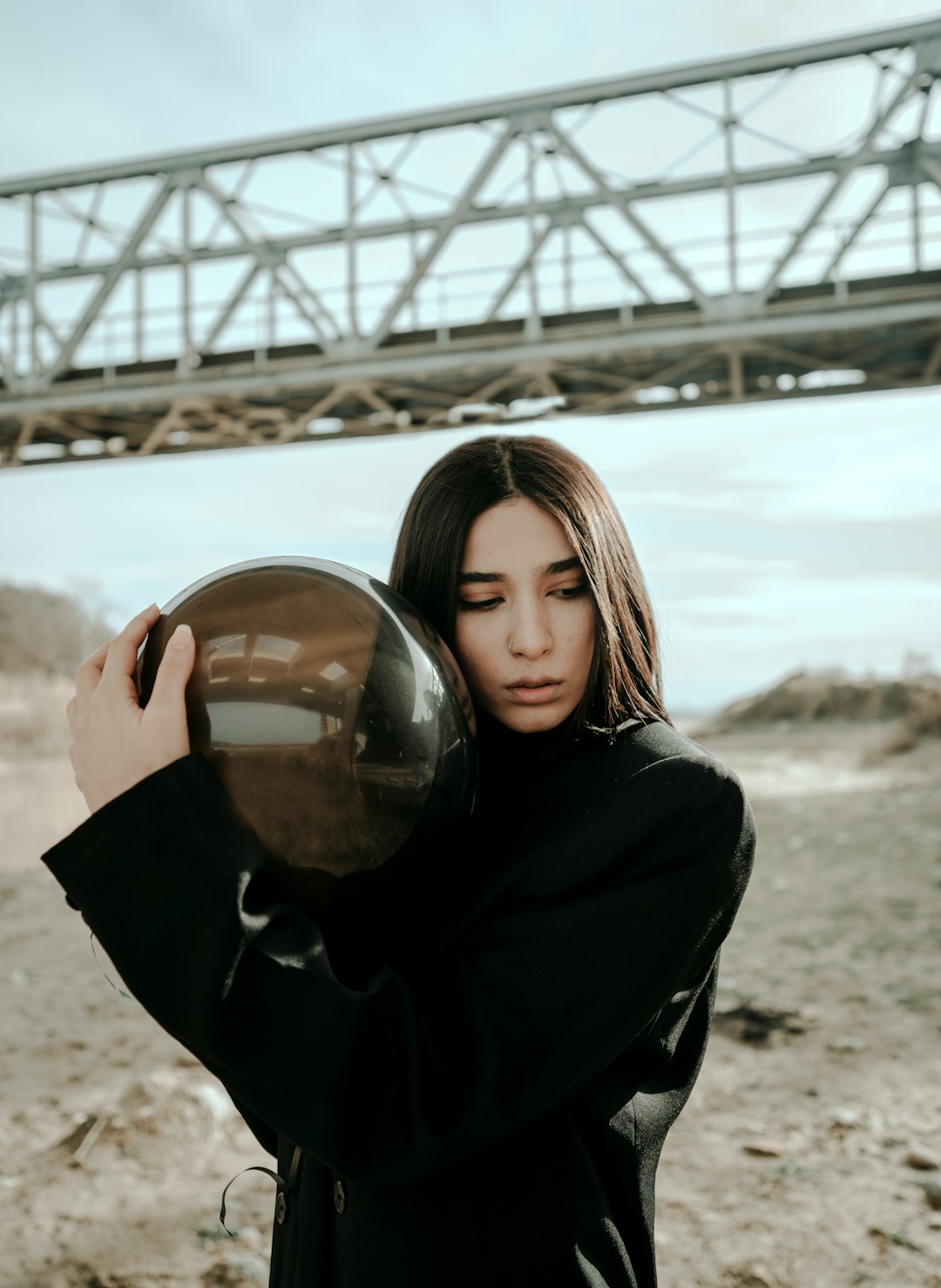 woman in black jacket holding clear glass ball