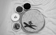 Freshly made rotis wrapped in a cloth, placed beside a bowl of tangy pickle.