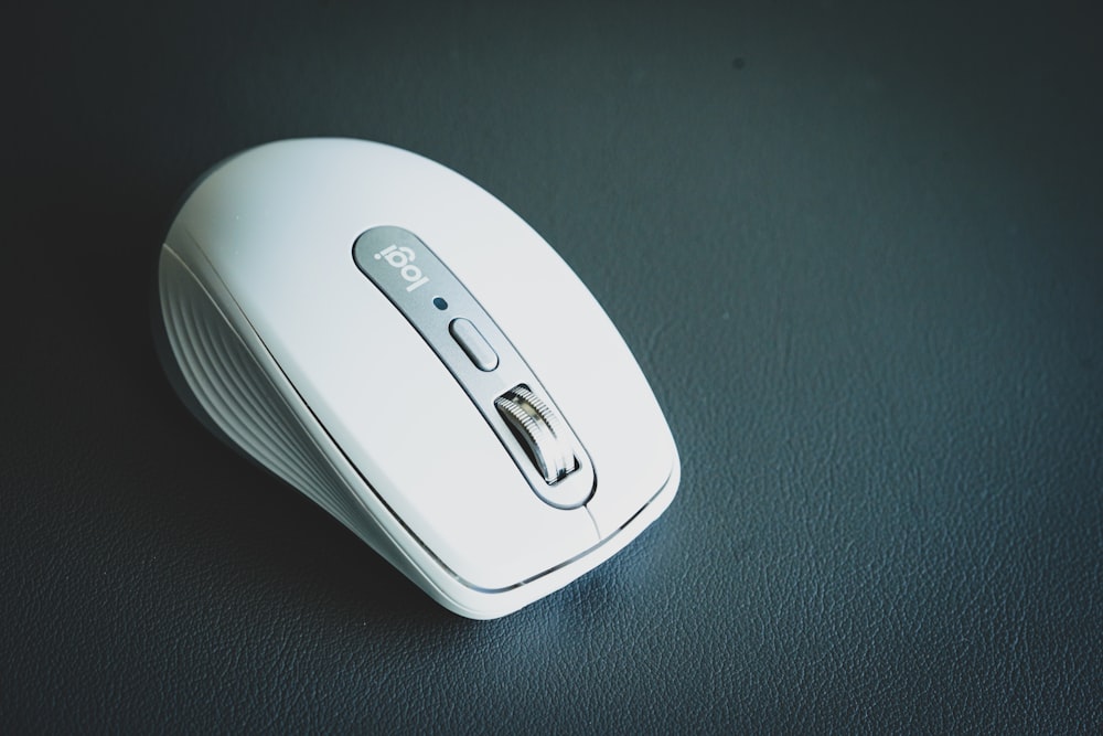 white wireless computer mouse on black surface