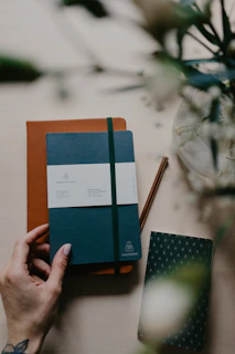 person holding blue and orange book
