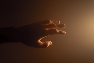 A comforting hand reaching out over a soft glowing light symbolizing healing energy.