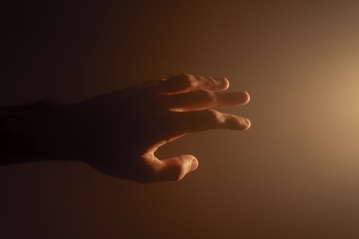 Hands glowing with soft energy light, demonstrating human energy fields.