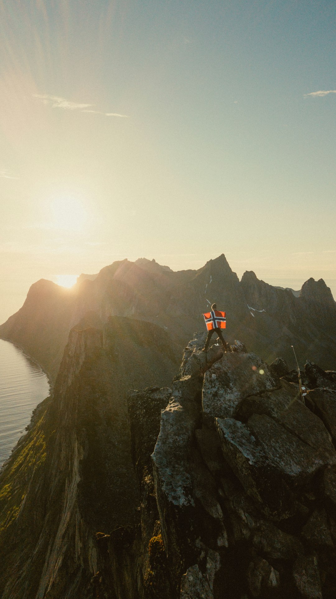 person standing on rock formation near body of water during daytime