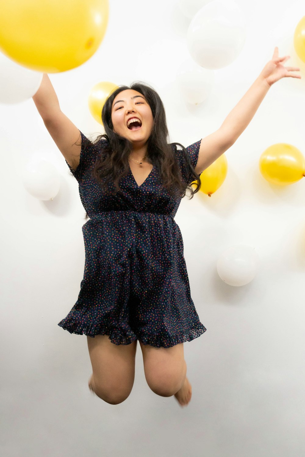 woman in black and white polka dot dress standing and smiling