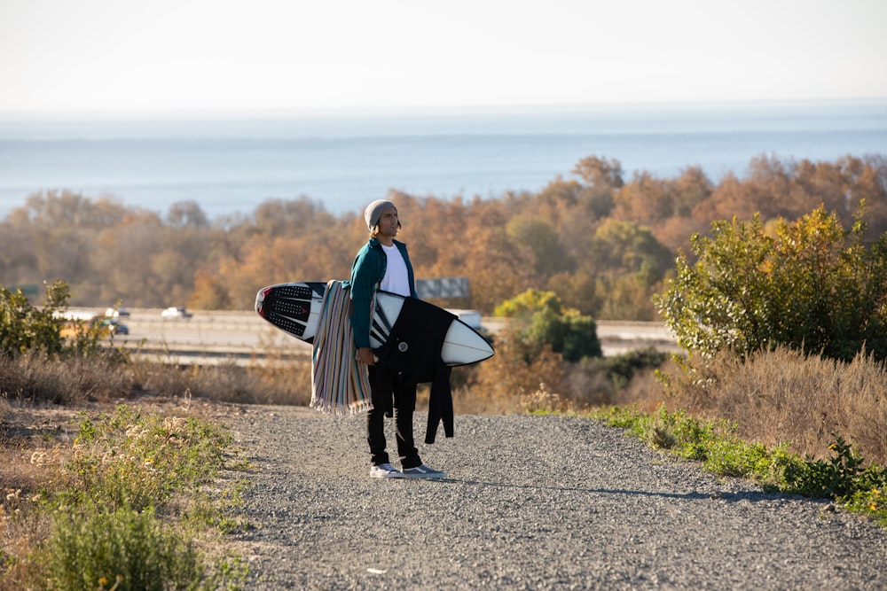 woman in black coat walking on gray asphalt road during daytime