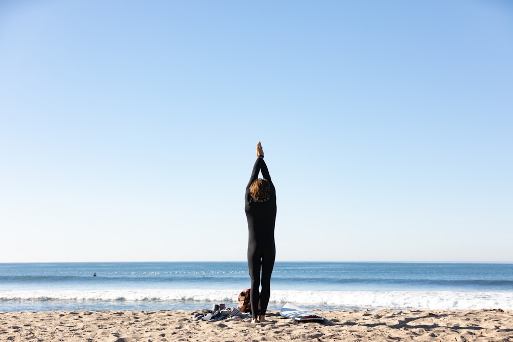 woman in black dress standing on beach during daytime