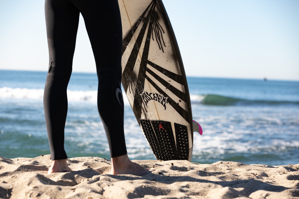 person holding black and white surfboard
